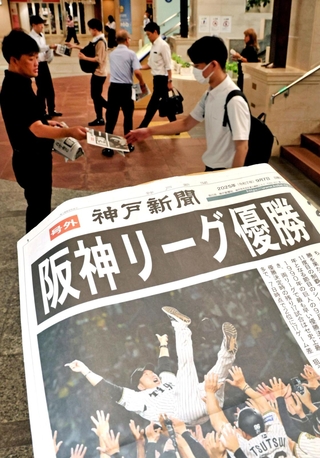出勤する人らに配られた阪神リーグ優勝を伝える神戸新聞の号外＝８日午前、神戸市中央区、デュオ神戸（撮影・小林良多）