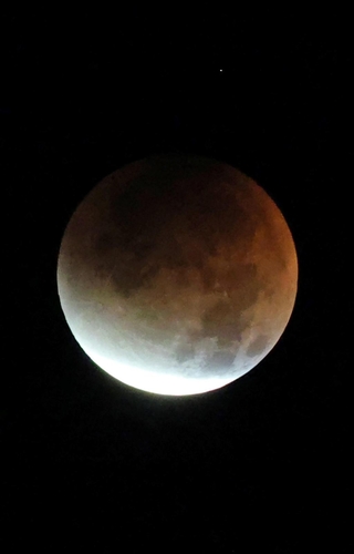 月食が進むと明るい部分はわずかになり、赤銅色が差し込む。この後まもなく「皆既食」に＝８日午前２時２６分、神戸市垂水区から（撮影・小林良多）