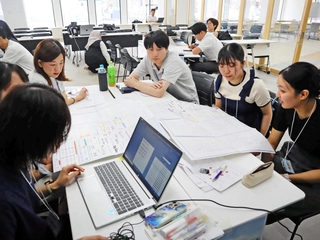 大学の強みを話し合い、ロゴの製作に取り組む学生たち＝神戸市中央区三宮町２