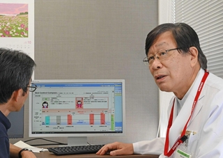 職員が手作りした病床管理ページを前に、事務系幹部と話す木下芳一院長（右）＝姫路市神屋町３、はりま姫路総合医療センター（撮影・斎藤雅志）