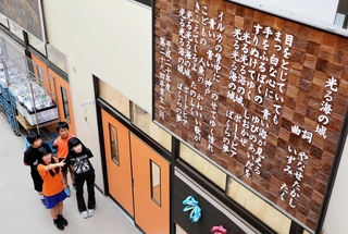 やなせたかしさんが作詞した「光る海の城」の歌詞を彫った木製パネル＝神戸市中央区港島中町３