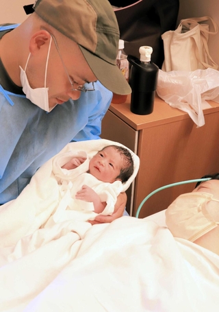 生まれたばかりの赤ちゃんを見つめる夫婦＝洲本市塩屋１、淡路医療センター