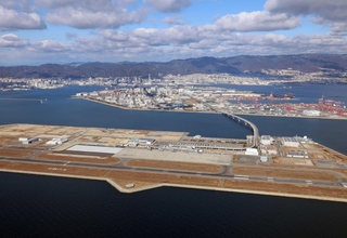 （手前から）神戸空港、ポートアイランド、神戸の市街地と六甲山系の山々。神戸市の都市経営は新時代を迎える＝２０２４年１２月、神戸空港上空付近から