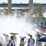 厳しい日差しが照りつける万博会場で、ミストを浴びて涼む来場者たち＝３１日午後、大阪市此花区の夢洲（撮影・大田将之）