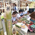 竹灯籠にメッセージを書き込む人たち＝１日午後、大阪市此花区の夢洲（撮影・斎藤雅志）