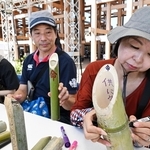 竹灯籠にメッセージを書き込む人たち＝１日午後、大阪市此花区の夢洲（撮影・斎藤雅志）