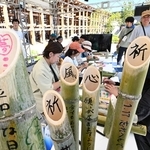竹灯籠にメッセージを書き込む人たち＝１日午後、大阪市此花区の夢洲（撮影・斎藤雅志）