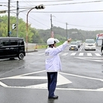 停電で信号が止まり、車両を手信号で誘導する警察官＝５日午前８時12分、淡路市竹谷