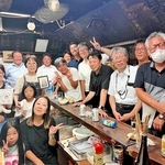 夫・正さんの写真を手にする木下和子さん（中央）を囲む常連客と家族＝神戸市兵庫区上庄通２