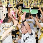 リーグ優勝が決まった瞬間。両手を挙げて喜び合うファン＝７日午後９時１１分、神戸市兵庫区大開通４、「タイガースバー　イレブン」