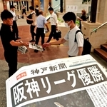 出勤する人らに配られた阪神リーグ優勝を伝える神戸新聞の号外＝８日午前、神戸市中央区、デュオ神戸（撮影・小林良多）