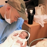 生まれたばかりの赤ちゃんを見つめる夫婦＝洲本市塩屋１、淡路医療センター