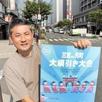 綱引き大会を実施する三宮中央通りでポスターを掲げる実行委代表の矢野克幸さん＝神戸市中央区三宮町２