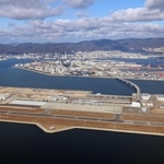 （手前から）神戸空港、ポートアイランド、神戸の市街地と六甲山系の山々。神戸市の都市経営は新時代を迎える＝２０２４年１２月、神戸空港上空付近から