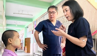 手術を終えた患者と向き合う河野朋子さん（右）ら＝８月、ミャンマー・ワッチェ村、ワッチェ慈善病院（ジャパンハート提供）