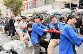 三宮と元町の境界線を巡って懸命に綱を引く参加者ら＝４日午後、神戸市中央区三宮町２