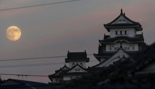 薄暮の空に浮かぶ「中秋の名月」と姫路城の大天守＝６日午後、姫路市山野井町から望む