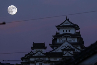 薄暮の空に浮かぶ「中秋の名月」と、姫路城の大天守＝６日午後、姫路市山野井町から望む