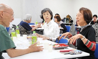 「元町おとなの給食会」で、昼食を食べながら会話に花を咲かせる参加者ら＝神戸市中央区元町通２