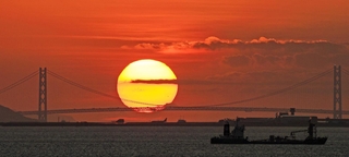 主塔の間に落ちる太陽＝６日午後、大阪市此花区の大阪・関西万博会場から