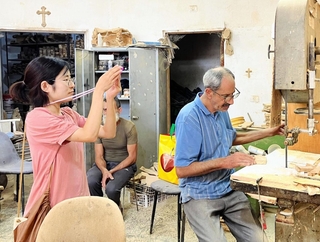 生産者の作業風景を撮影する高橋智恵さん（左）＝パレスチナ自治区ヨルダン川西岸地区（２０２５年８月、高橋さん提供）