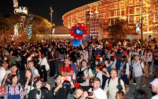 ミャクミャクの像が見守る中、名残惜しそうに家路につく来場者たち＝１３日夜、大阪市此花区の夢洲（撮影・鈴木雅之）