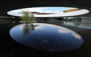 報道陣に公開された迎賓館。円形の屋根から光が差し込む水盤には柳の木も＝１５日午後、大阪市此花区の夢洲（撮影・笠原次郎）
