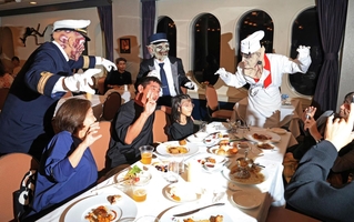 ゾンビ船長やフランケン料理長らが食事中の乗客のテーブルを訪れ、ハロウィーンを盛り上げる＝神戸港沖