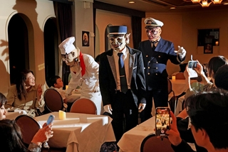 ゾンビ船長やフランケン料理長らが食事中の乗客のテーブルを訪れ、ハロウィーンを盛り上げる＝神戸港沖