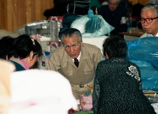 避難所を訪問し被災者を励ます村山富市首相（中央、肩書は当時）ら＝１９９５年３月、神戸市東灘区、御影小学校