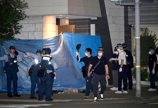 入り口にブルーシートが張られ、捜査員が出入りする現場マンション＝８月２０日夜、神戸市中央区
