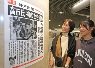 高市早苗氏が初の女性首相に選ばれたことを伝える張り出し号外を見る人たち＝２１日午後、神戸市中央区、デュオこうべ（撮影・笠原次郎）