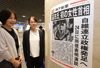 高市早苗氏が初の女性首相に選ばれたことを伝える張り出し号外を見る人たち＝２１日午後、神戸市中央区、デュオこうべ（撮影・笠原次郎）