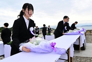 戦没学徒を追悼し、献花する若年世代代表の佐々木麻那さん（手前）ら＝南あわじ市阿万塩屋町