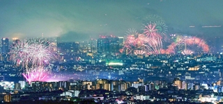 １０月１８日に同時に開催された伊丹（左）と淀川の花火大会。大輪が市街地を彩った＝宝塚市内から望む