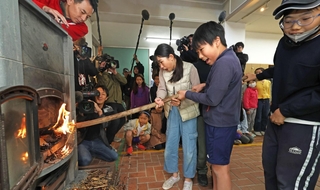 自分たちでおこした火をストーブにともす児童たち＝２３日午前、神戸市灘区六甲山町、六甲山小学校（撮影・鈴木雅之）