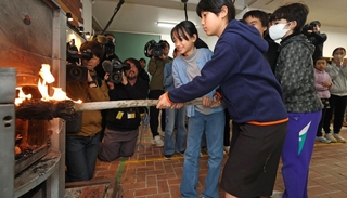 自分たちでおこした火をストーブにともす児童たち＝２３日午前、神戸市灘区六甲山町、六甲山小学校（撮影・鈴木雅之）