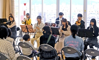 患者や住民の前で演奏を披露する県立大学の学生たち＝神戸市長田区二葉町５、野瀬病院