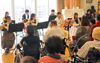 患者や住民の前で演奏を披露する県立大学の学生たち＝神戸市長田区二葉町５、野瀬病院