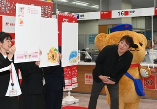 発売された年賀はがきのデザインを見る元阪神タイガース選手の濱中治さん（右）＝３０日午前、神戸市中央区栄町通６、神戸中央郵便局（撮影・斎藤雅志）