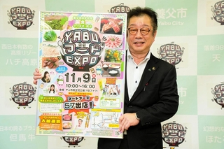 養父市の食イベントのポスターを掲げる大林賢一市長＝同市八鹿町八鹿