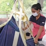 介護リフトを操作するスリランカ人のデームニ・ハンサニ・ナオーディヤ・ピリヤダルシャニさん（右）＝神戸市北区山田町小部、六甲の館（撮影・笠原次郎）