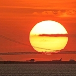 主塔の間に落ちる太陽＝６日午後、大阪市此花区の大阪・関西万博会場から（撮影・吉田敦史）