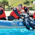 水面の要救助者をボートへ引き上げる署員ら＝姫路セントラルパーク