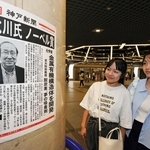 北川進氏のノーベル化学賞受賞を伝える号外を見る人たち＝８日夜、神戸市中央区、デュオこうべ（撮影・笠原次郎）