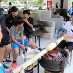 約１００年前の製法でバウムクーヘンを作る子どもたち＝広島市南区、ユーハイム似島歓迎交流センター