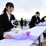 戦没学徒を追悼し、献花する若年世代代表の佐々木麻那さん（手前）ら＝南あわじ市阿万塩屋町