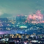 １０月１８日に同時に開催された伊丹（左）と淀川の花火大会。大輪が市街地を彩った＝宝塚市内から望む