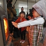 火がともったストーブで暖を取る児童たち＝２３日午前、神戸市灘区六甲山町、六甲山小学校（撮影・鈴木雅之）