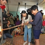 自分たちでおこした火をストーブにともす児童たち＝２３日午前、神戸市灘区六甲山町、六甲山小学校（撮影・鈴木雅之）